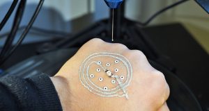 A new 3-D printer builds temporary electronics on your skin